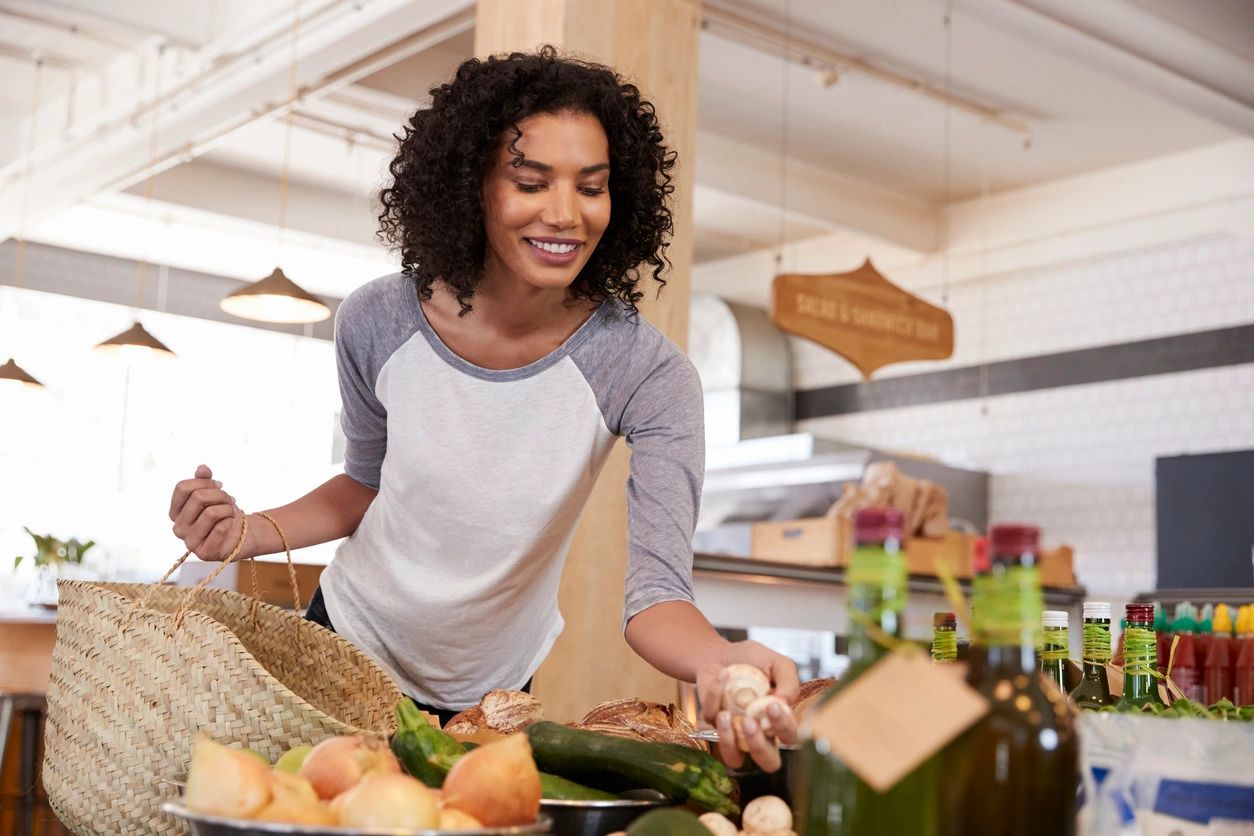 shopper picking out fresh product packed in Wellspring's knitted tubular netting